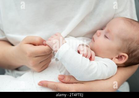 Il tocco morbido del bambino che stringe il dito della madre parla molto. Concetto di pura connessione madre-figlio Foto Stock