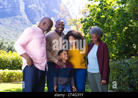 Ritratto di una felice famiglia afroamericana che abbraccia nel soleggiato cortile, spazio fotocopie Foto Stock