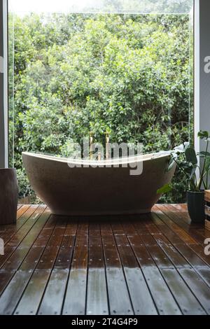 Bagno moderno con enorme finestra con vista sugli alberi nel bagno soleggiato Foto Stock