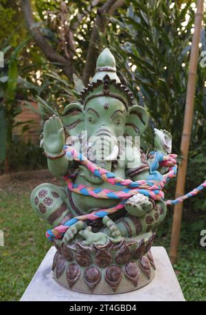 Thailandia: Una statua del dio indù Ganesh nel giardino di una grande casa privata vicino al fiume Ping, Chiang mai. Ganesha, scritto anche Ganesa o Ganesh, e conosciuto anche come Ganapati, Vinayaka e Pillaiyar, è una delle divinità più conosciute e più venerate nel pantheon indù. La sua immagine si trova in tutta l'India e il Nepal. Le sette indù lo adorano indipendentemente dalle affiliazioni. La devozione a Ganesha è ampiamente diffusa e si estende ai gialli, ai buddisti e oltre l'India. Foto Stock