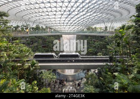 Lo Sky Train si sposta all'interno dell'interno dell'aeroporto Jewel Changi per ammirare gli interni lussureggianti e verdi e le cascate al coperto più alte del mondo. Singapore Foto Stock