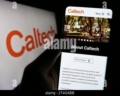 Persona che possiede uno smartphone con una pagina Web dell'University California Institute of Technology (Caltech) con logo. Concentrarsi sul centro del display del telefono. Foto Stock