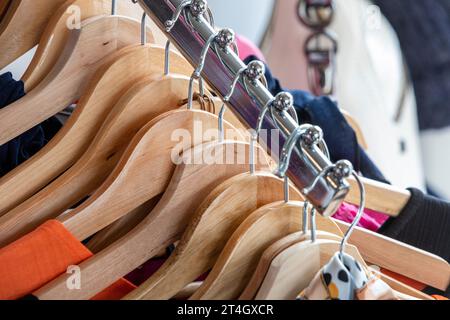 Appendiabiti in legno su un binario in un negozio di moda nello Yorkshire Foto Stock