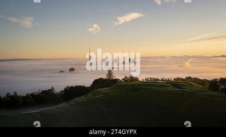 Sky Tower e Auckland città nella nebbia all'alba, dalla cima del Monte Eden. Foto Stock