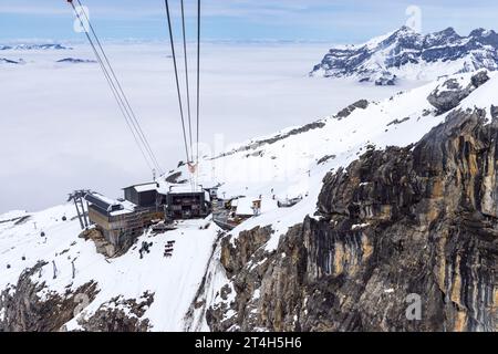 Paesaggio innevato con vista sulla stazione inferiore della funivia dalla cima del Monte Titlis a 3020 metri di altitudine a Engelberg, Svizzera Foto Stock