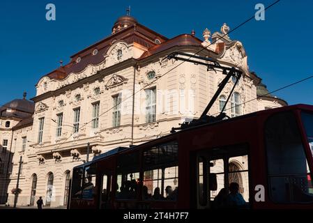 Bratislava, Slovacchia. 2 ottobre 2023 Un tram che passa davanti alla bellissima sala concerti di epoca barocca Reduta Bratislava, sede della Filarmonica di Stato slovacca, Foto Stock