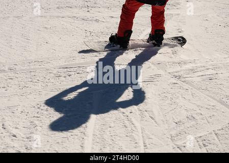 Snowboarder sulla pista da sci con ombra o. snowboarder su una pista da sci in montagna. dolomiti di Civetta, alpi. Foto Stock