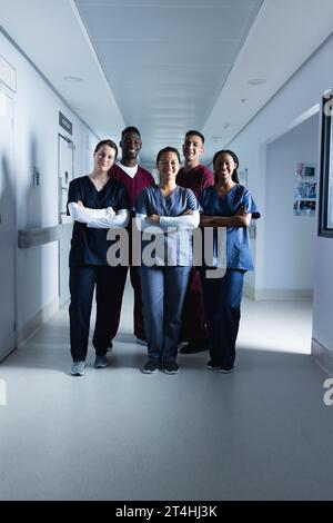 Ritratto di medici maschi e femmine felici e diversificati che indossano scrub in ospedale Foto Stock