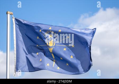 Bandiera dello stato dell'Indiana che sventola nel vento contro il cielo blu Foto Stock