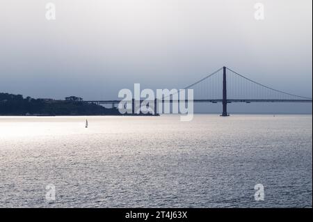 Una barca a vela nella Baia di San Francisco con il Golden Gate Bridge sullo sfondo al tramonto Foto Stock