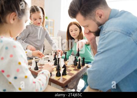 Ritratto di una bella famiglia incentrata sull'intellettuale che gioca a scacchi con papà solo che impara a studiare tempo libero a casa, nel salotto di casa Foto Stock