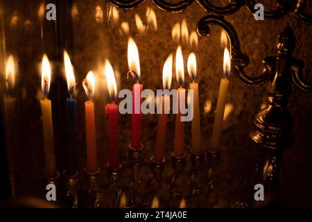 Le candele multicolore di cera Hanukkah bruciano in una menorah durante la celebrazione del festival ebraico delle luci. Foto Stock