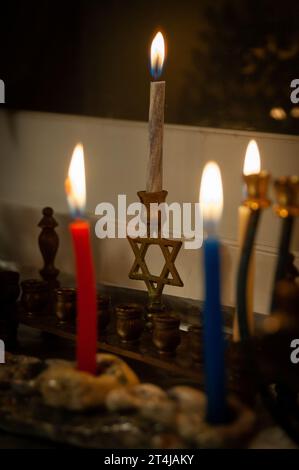 Le candele multicolore di cera Hanukkah bruciano in una menorah durante la celebrazione del festival ebraico delle luci. Foto Stock