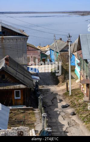 Strada costiera vicino al fiume Volga con vecchie case in legno a Gorodets, Russia Foto Stock