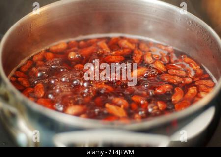 Fagioli bolliti in acqua bollente da vicino. Cucinare piatti vegetariani fatti in casa Foto Stock