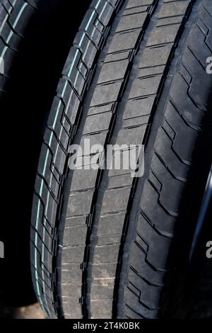 Primo piano dei nuovi pneumatici del carrello che mostrano un battistrada profondo e contrassegni di sicurezza. Foto Stock