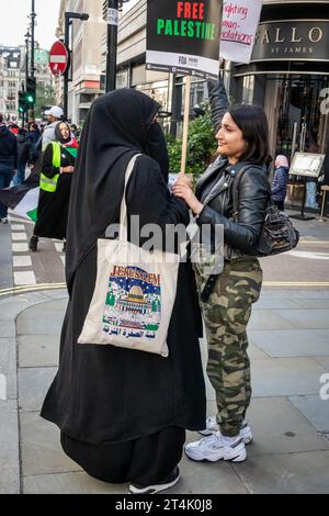 I manifestanti si fermano brevemente mentre i manifestanti marciano verso Trafalgar Square. Foto Stock