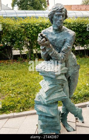 Nizhny Novgorod, Russia. 29 maggio 2023. Scultura di un venditore di giornali nel parco. La figura di un giovane con una pila di giornali e un cellulare Foto Stock