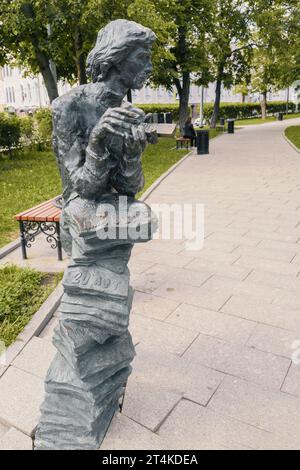 Nizhny Novgorod, Russia. 29 maggio 2023. Scultura di un venditore di giornali nel parco. La figura di un giovane con una pila di giornali e un cellulare Foto Stock