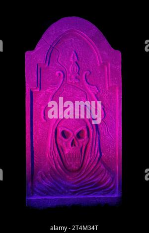 Halloween Pink, Purple e Blue Lit Tombstone con teschio che si illumina al buio Foto Stock