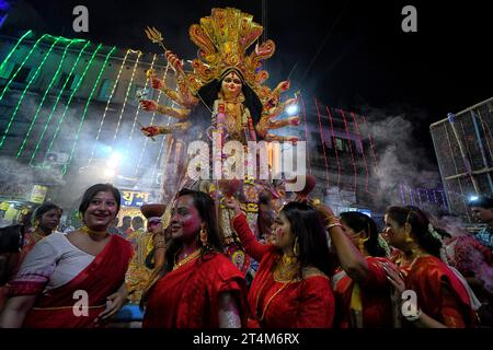 Kolkata, India. 25 ottobre 2023. Le donne vestite con abiti tradizionali bengalesi eseguono la danza dhunuchi durante la processione di immersione a Bagbazar. Durga Puja, un festival annuale che segna la vittoria del bene sul male, è celebrato dagli indù in tutta l'India e all'estero. E' un'occasione di grande entusiasmo e festa per gli indù. L'ultimo giorno, il giorno di Bhashan o Vijoya Dashami immagini e idoli sono immersi nell'acqua. (Immagine di credito: © Avishek Das/SOPA Images via ZUMA Press Wire) SOLO USO EDITORIALE! Non per USO commerciale! Foto Stock