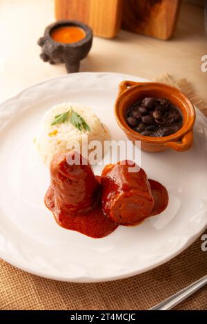 Involtini di carne con adobo, ripieni di formaggio, verdure o altri ingredienti e serviti con riso e fagioli, chiamati anche in Messico come Wrapped Child o. Foto Stock