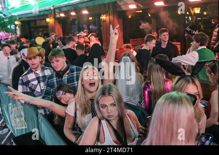 Broad Street, Birmingham, 31 ottobre 2023 - migliaia di festeggiamenti sono usciti martedì sera per festeggiare Halloween. La pioggia ha iniziato a diventare leggera, diventando pesante vicino a mezzanotte, ma ciò non ha smorzato gli spiriti. Alcuni hanno usato cappotti per ripararsi e altri hanno improvvisato con sacchetti di plastica sulla famigerata strada della vita notturna di Birmingham. Il Bier Bar di Heidi era tutto esaurito con una politica "one in, one out" imposta perché le code si estendevano lungo la strada in una delle loro notti più trafficate dell'anno. Nonostante il freddo e il clima umido, ciò non ha impedito alcuni costumi sorprendenti, tra cui un ragazzo con una felpa con cappuccio Just Stop Oil arancione, Una donna dr Foto Stock