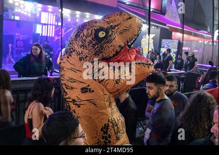 Broad Street, Birmingham, 31 ottobre 2023 - migliaia di festeggiamenti sono usciti martedì sera per festeggiare Halloween. La pioggia ha iniziato a diventare leggera, diventando pesante vicino a mezzanotte, ma ciò non ha smorzato gli spiriti. Alcuni hanno usato cappotti per ripararsi e altri hanno improvvisato con sacchetti di plastica sulla famigerata strada della vita notturna di Birmingham. Il Bier Bar di Heidi era tutto esaurito con una politica "one in, one out" imposta perché le code si estendevano lungo la strada in una delle loro notti più trafficate dell'anno. Nonostante il freddo e il clima umido, ciò non ha impedito alcuni costumi sorprendenti, tra cui un ragazzo con una felpa con cappuccio Just Stop Oil arancione, Una donna dr Foto Stock