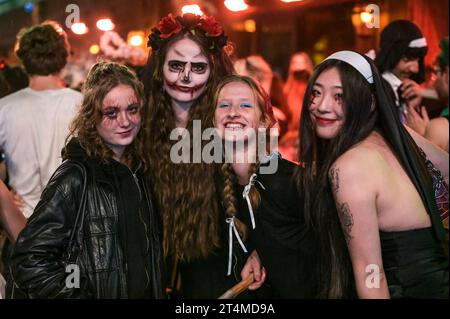 Broad Street, Birmingham, 31 ottobre 2023 - migliaia di festeggiamenti sono usciti martedì sera per festeggiare Halloween. La pioggia ha iniziato a diventare leggera, diventando pesante vicino a mezzanotte, ma ciò non ha smorzato gli spiriti. Alcuni hanno usato cappotti per ripararsi e altri hanno improvvisato con sacchetti di plastica sulla famigerata strada della vita notturna di Birmingham. Il Bier Bar di Heidi era tutto esaurito con una politica "one in, one out" imposta perché le code si estendevano lungo la strada in una delle loro notti più trafficate dell'anno. Nonostante il freddo e il clima umido, ciò non ha impedito alcuni costumi sorprendenti, tra cui un ragazzo con una felpa con cappuccio Just Stop Oil arancione, Una donna dr Foto Stock