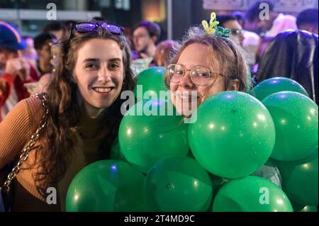 Broad Street, Birmingham, 31 ottobre 2023 - migliaia di festeggiamenti sono usciti martedì sera per festeggiare Halloween. La pioggia ha iniziato a diventare leggera, diventando pesante vicino a mezzanotte, ma ciò non ha smorzato gli spiriti. Alcuni hanno usato cappotti per ripararsi e altri hanno improvvisato con sacchetti di plastica sulla famigerata strada della vita notturna di Birmingham. Il Bier Bar di Heidi era tutto esaurito con una politica "one in, one out" imposta perché le code si estendevano lungo la strada in una delle loro notti più trafficate dell'anno. Nonostante il freddo e il clima umido, ciò non ha impedito alcuni costumi sorprendenti, tra cui un ragazzo con una felpa con cappuccio Just Stop Oil arancione, Una donna dr Foto Stock