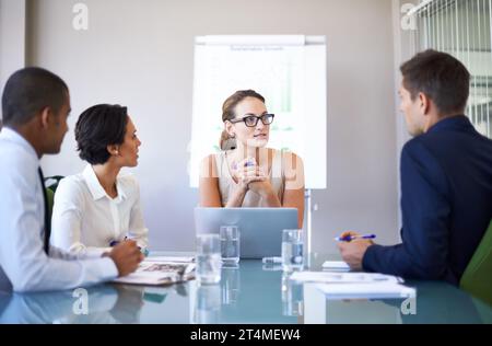È un team estremamente ambizioso. Un gruppo di uomini d'affari che ascoltano i loro colleghi durante una riunione. Foto Stock