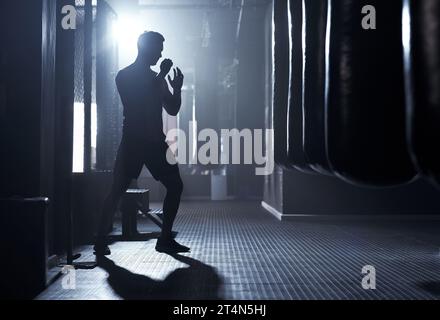 Un guerriero non si preoccupa mai della sua paura. un giovane sportivo kickboxing in palestra. Foto Stock