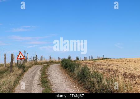 Gli aerei hanno la priorità - immagine di una strada sterrata con un cartello stradale che dà la priorità agli aerei Foto Stock