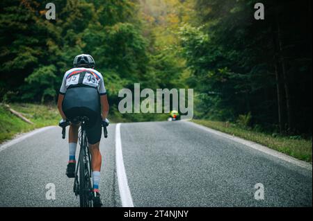 Ciclista su strada nella verde natura estiva. Foto dello sport, tema del ciclismo. . Preparazione per la gara ciclistica professionale Tour a luglio in Francia. Sfocato Foto Stock