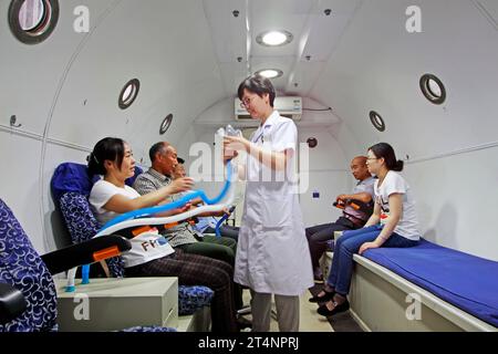 Luannan - giugno 29: Guida medica pazienti che indossano maschere per ossigeno nella camera iperbarica di ossigeno, il 29 giugno 2015, contea luannana, provincia di hebei, Chin Foto Stock