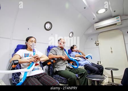 Luannan - giugno 29: Pazienti che indossano maschere per ossigeno, nella camera di ossigeno iperbarica, il 29 giugno 2015, contea luannana, provincia di hebei, Cina Foto Stock