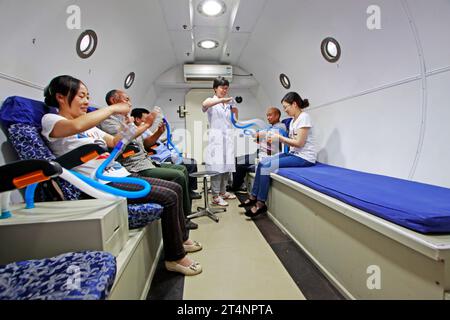 Luannan - giugno 29: Guida medica pazienti che indossano maschere per ossigeno nella camera iperbarica di ossigeno, il 29 giugno 2015, contea luannana, provincia di hebei, Chin Foto Stock