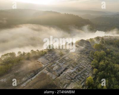 Vista aerea del sito archeologico di l'Esquerda, a Roda de ter, su un'alba nebbiosa (Osona, Barcellona, Catalogna, Spagna) Foto Stock