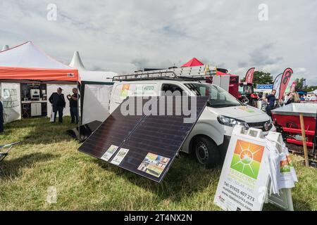 Nantwich, Cheshire, Inghilterra, 26 luglio 2023. Pannelli solari con un furgone bianco sullo sfondo in una fiera campestre, illustrazione editoriale sull'energia. Foto Stock