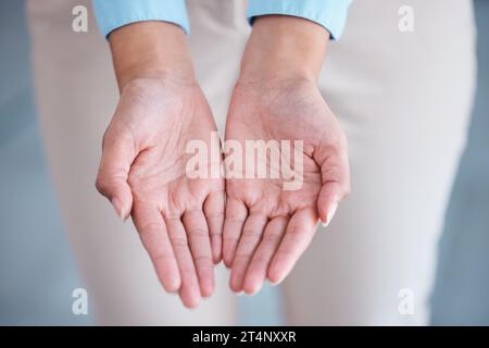 Vista superiore e primo piano di due mani estese con i palmi aperti in un gesto donatorio e ricevente. Donna d'affari sconosciuta di razza mista che chiede aiuto Foto Stock