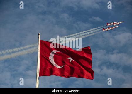 Istanbul, Turchia. 29 ottobre 2023. In occasione del 100° anniversario della fondazione della Repubblica di Turchia, la bandiera turca è stata vista sventolare nei cieli del Bosforo mentre la squadra acrobatica Turkish Stars dell'Aeronautica militare turca ha effettuato un volo dimostrativo. Le stelle turche e SOLOTURK hanno fatto un volo dimostrativo nei cieli del Bosforo in occasione del 100° anniversario della fondazione della Repubblica di Turchia. Come parte degli eventi della Festa della Repubblica, 100 navi navali della Marina turca tennero una parata ufficiale nel Bosforo. (Immagine di credito: © Onur Dogman/SOPA Foto Stock