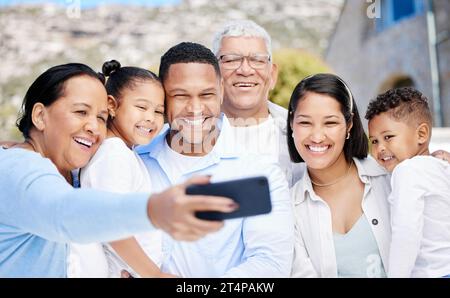 Tutti quanti, stringete. una bella famiglia che fa un selfie insieme mentre si unisce all'esterno. Foto Stock