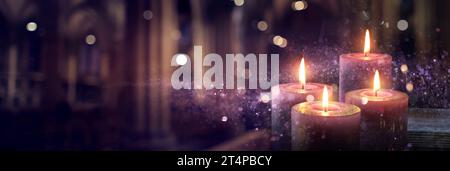 Advent Candles Burning in the Dark con glitter sulle fiamme e Abstract Defocus Lights Foto Stock