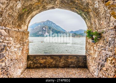 Balcone panoramico con arco di roccia che si affaccia sul Lago di Como e sulla città di Menaggio in lontananza, Varenna, Italia Foto Stock