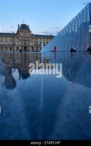 Ammira le piramidi di vetro del palazzo del Louvre al tramonto Foto Stock