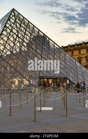 Ammira le piramidi di vetro del palazzo del Louvre al tramonto Foto Stock