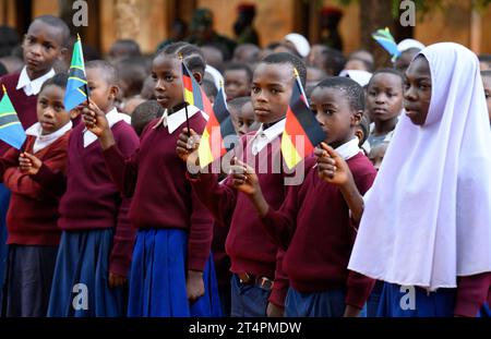 Songea, Tanzania. 1 novembre 2023. Gli allievi della scuola elementare Maji-Maji di Songea si trovano nel cortile della scuola con bandiere tedesche e tanzaniane durante la visita del presidente Steinmeier. Steinmeier ha concluso il suo viaggio in Tanzania mercoledì con la sua visita a Songea. Crediti: Bernd von Jutrczenka/dpa/Alamy Live News Foto Stock