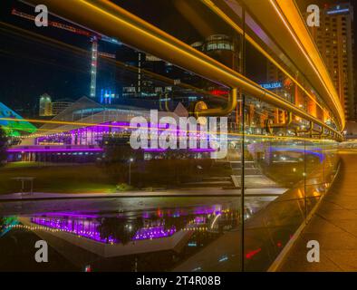 Vista dello skyline della città di notte, presa da un ponte pedonale sul fiume Torrens Foto Stock