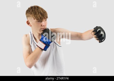 Un adolescente caucasico che indossa guanti da boxe in stile MMA Foto Stock