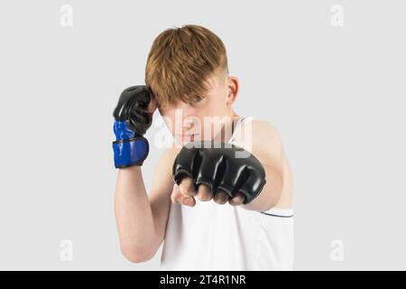 Un adolescente caucasico che indossa guanti da boxe in stile MMA Foto Stock